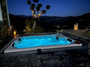 een jacuzzi op een patio 's nachts bij Casinha Serabigoes Arouca Passadiços Paiva in Arouca