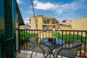 a patio with a table and chairs on a balcony at Corfu Blue Memories Apartment 1 in Corfu Town
