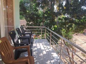 three chairs and a table on a porch at Ocean Mist Beach Homestay in Māvalli