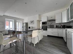 a kitchen with white cabinets and a table and chairs at La Bella Vigna - Essoyes - 6 prs - 3 bdr in Essoyes