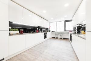 a white kitchen with white counters and a large window at Yugo Explore New Mill in Dublin +8 photos