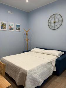 a bedroom with a bed and a clock on the wall at Don Mimì Casa Vacanza in Torre del Greco +30 photos