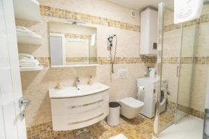 a bathroom with a sink and a toilet and a shower at Apartments Toni in Baška