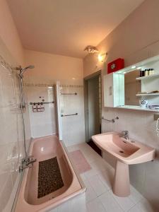 a bathroom with a pink tub and a sink at B&B al Vittoriale da Maja in Gardone Riviera +57 photos