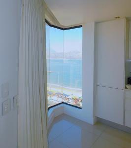 a room with a large window with a view of the ocean at Penthouse Strand in Strand
