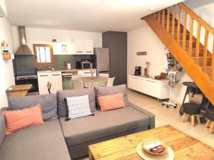 a living room with a couch and a kitchen at Gîte des deux platanes in Orgon