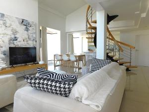 a living room with a white couch with pillows on it at Penthouse Strand in Strand