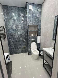 a bathroom with a toilet and a sink at ЖК Central Park in Aktobe