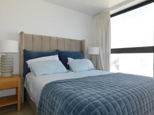 a bedroom with a large bed with a blue comforter at Penthouse Strand in Strand
