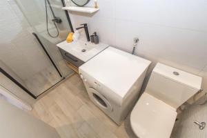 a white bathroom with a toilet and a shower at Apartments Njoko in Prvić Šepurine +37 photos