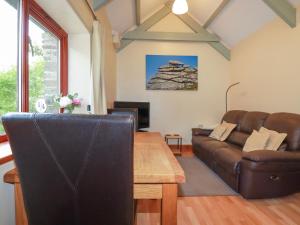 a living room with a couch and a table at Barn Cottage in Liskeard +11 photos