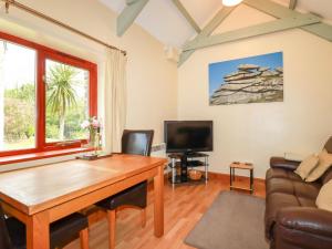 a living room with a table and a couch at Barn Cottage in Liskeard