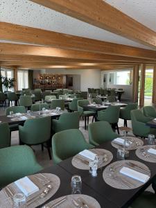 CollombeyにあるAlp Art Hotel Montheyのダイニングルーム(テーブル、緑の椅子付)
