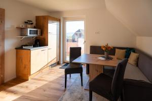 a living room with a dining room table and a kitchen at Apartment - Wolfsberg in Sankt Johann