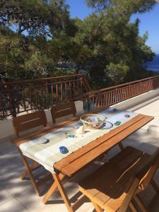 a wooden table with a bowl on top of a deck at Villa Luminosa Kyra Panagia in Kyra Panagia