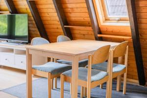 - une table et des chaises en bois dans l'établissement Ferienwohnpark Immenstaad am Bodensee Nurdachhaus Typ 7 ND 50, à Immenstaad am Bodensee