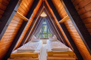 deux lits dans une chambre en bois avec une fenêtre dans l'établissement Ferienwohnpark Immenstaad am Bodensee Nurdachhaus Typ 7 ND 50, à Immenstaad am Bodensee