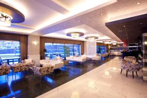 a hotel lobby with tables and chairs and a piano at Limak Ambassadore Hotel Ankara in Ankara