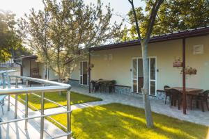 a patio of a house with a table and chairs at Guest House Nevena in Shabla