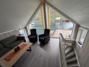 a living room with a couch and chairs and a large window at Waterfront Suite l Ballstad l Lofoten l Norway in Ballstad