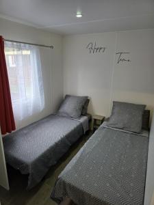 a bedroom with two beds and a window at Valras Cabane du Soleil Mobil home cosy in Sérignan +14 photos