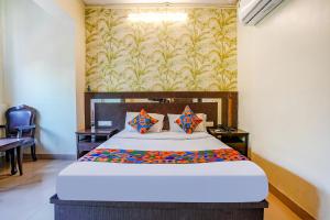 a bedroom with a bed and a wall with a wallpaper at FabHotel Gargi Deluxe in Pune