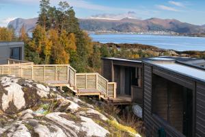 ein Haus auf einem Hügel mit Blick auf das Wasser in der Unterkunft Torvika Seaview Pods in Bølandet + 16 Fotos