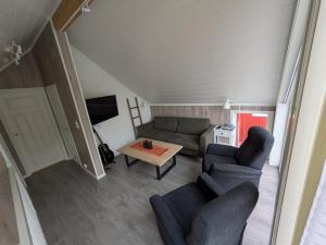 a living room with two couches and a table at Waterfront Suite l Ballstad l Lofoten l Norway in Ballstad +16 photos