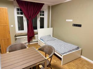 una habitación con una cama y una mesa y una ventana en Monteur-Freundliche Apartments, en Bergisch Gladbach