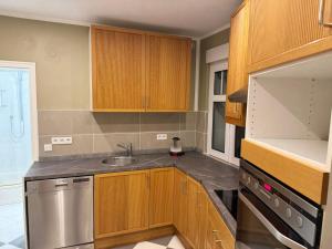 Una cocina con gabinetes de madera y un fregadero. en Monteur-Freundliche Apartments, en Bergisch Gladbach