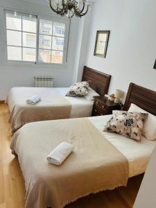 a bedroom with two beds and a chandelier at Miguel Servet con GARAJE INCLUIDO in Zaragoza