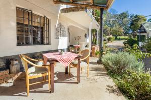 a table and chairs on the patio of a house at Hebron Haven Hotel in Dargle