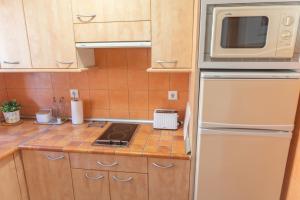 a kitchen with a stove and a microwave at Apartamento Sereno 4 | Piscina, Garaje, Terraza y Playa in Los Caños de Meca