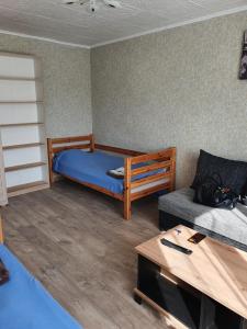una piccola stanza con un letto e un divano di Apartament Erfolg 7 a Daugavpils