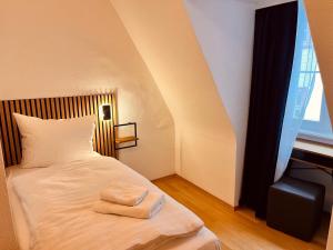 a bedroom with a bed with two towels on it at Hotel Zum Pfalzgrafen in Heidelberg