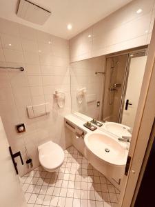 a white bathroom with a toilet and a sink at Hotel Zum Pfalzgrafen in Heidelberg
