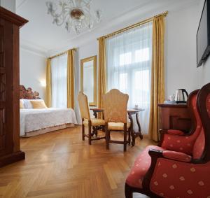 a bedroom with a bed and a table and chairs at Charles Bridge Palace in Prague