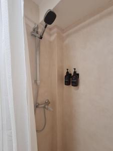 a bathroom with a shower with two bottles on the wall at Alba Odeceixe - casa baixa in Odeceixe