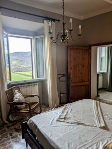 a bedroom with a bed and a large window at Il Muro d'Oro in San Dalmazio