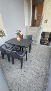a picnic table with two chairs and a vase with flowers at Guesthouse Angelina-Koko in Sighnaghi +21 photos
