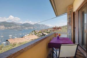 a balcony with a table and chairs and a view of the water at Casa Edda in Brenzone sul Garda