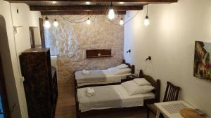 Zimmer mit 3 Betten in einem Zimmer mit einem Tisch in der Unterkunft Rustic Home Maslenica in Maslenica