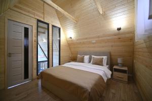 a bedroom with a large bed in a wooden wall at Avra Resort Tsaghkadzor in Tsaghkadzor +141 photos