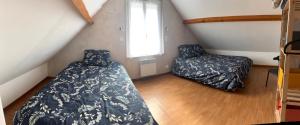 a attic bedroom with two beds and a window at Gîte Bellevue in Ossen