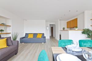 un soggiorno con un divano, un tavolo e delle sedie di Heart of Paris-1BR- 6P - Les Halles - Free Netflix a Parigi