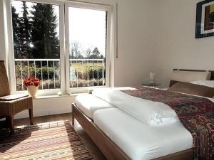 a bedroom with a large bed and a large window at "Villa Lorenzo" in Bad Zwischenahn