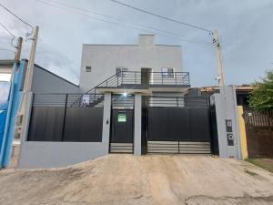 a white house with a gate and a door at Pousada do sol in Sorocaba
