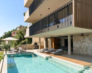 a house with a swimming pool in front of a building at Villa Eleven in Dubrovnik