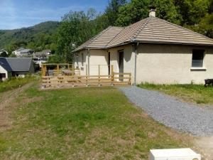 a house with a wooden fence in the yard at maison individuelle in Laveissière