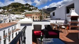a balcony with chairs and a table with a view at Casa Pegelow in Frigiliana